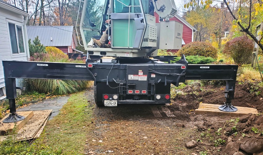 The Hill Treekeepers crane balanced on boards to distribute weight and avoid yard damage in Modena, NY.